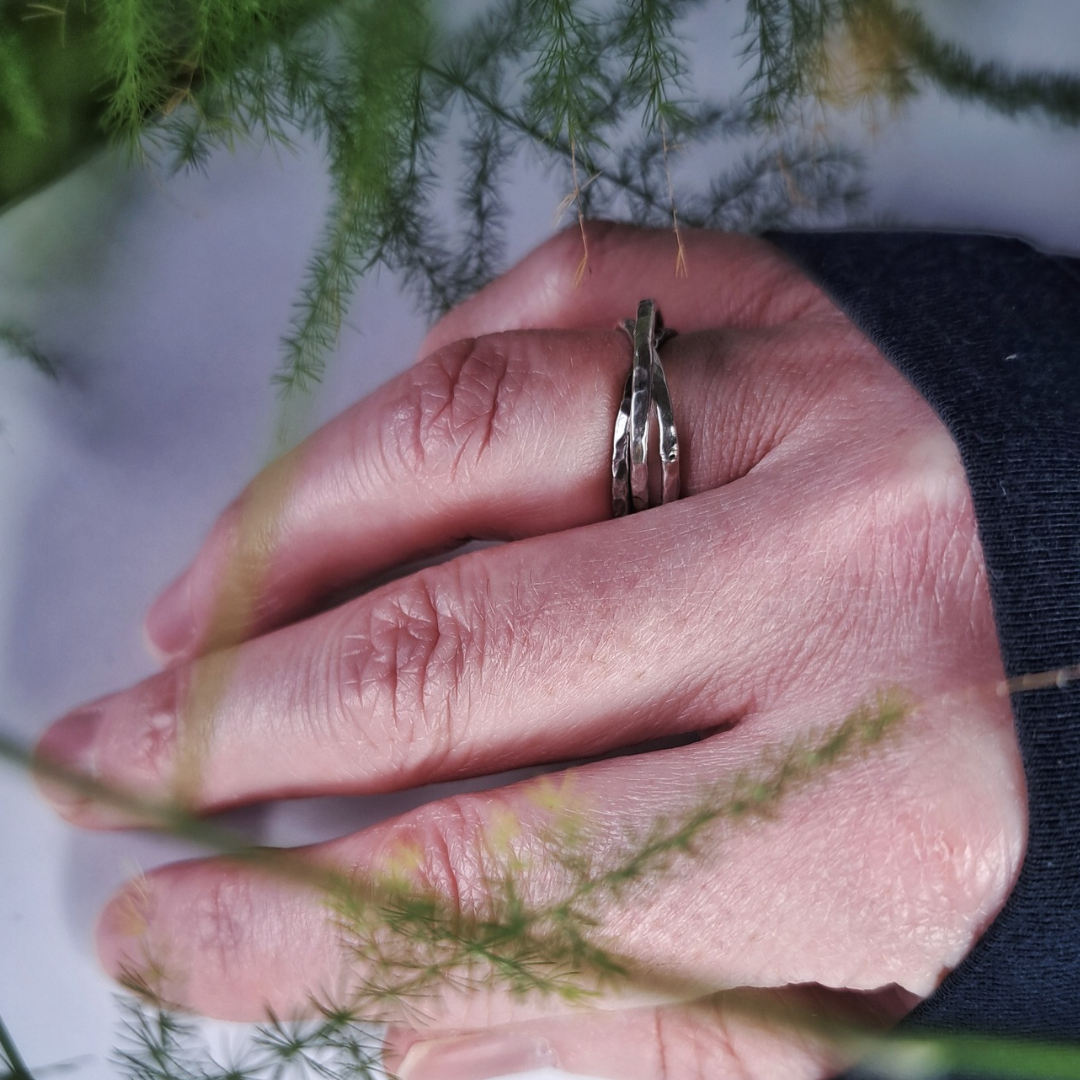 Triple band hammered silver ring worn on hand outdoors
