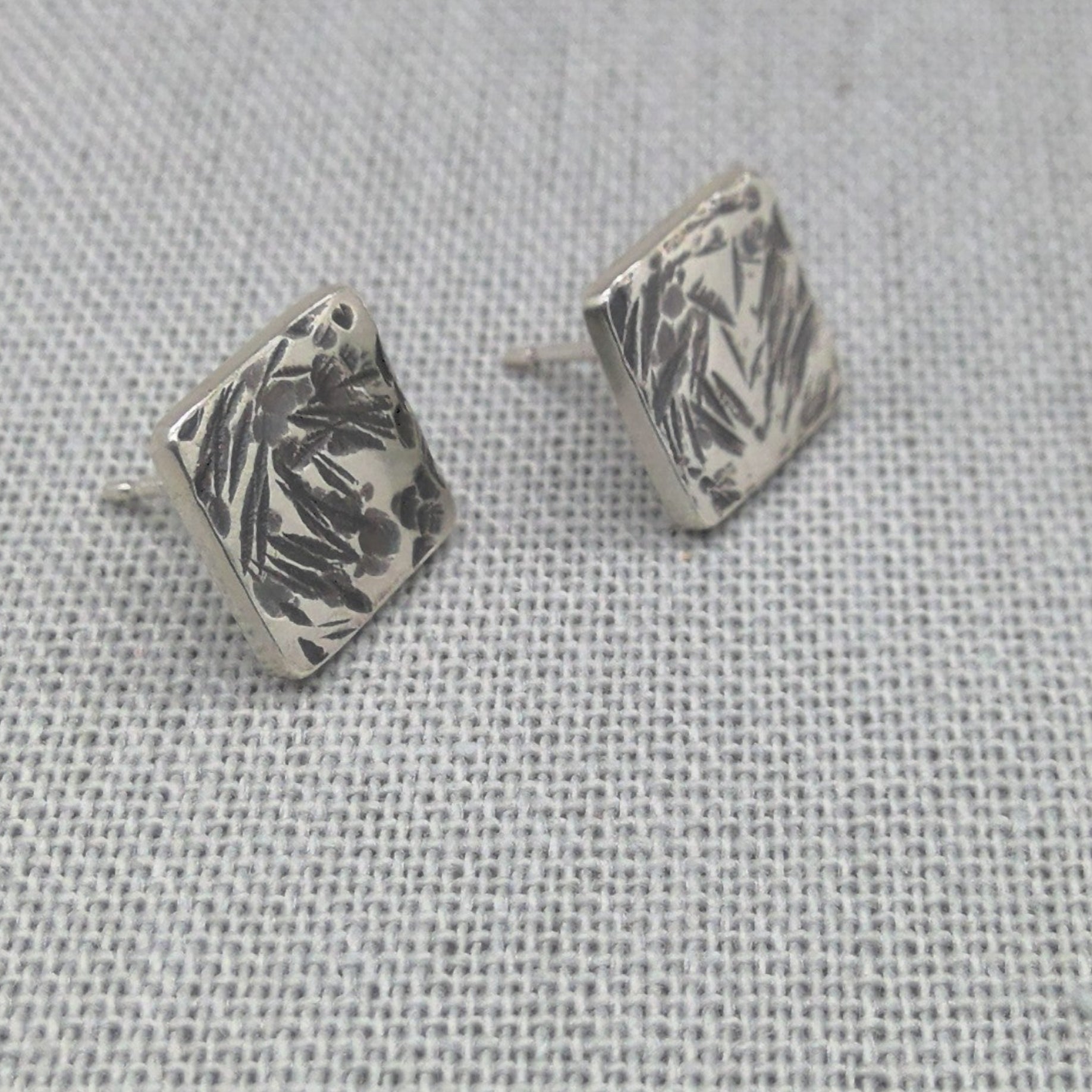 Detail shot of hammered square stud earring showing silver texture