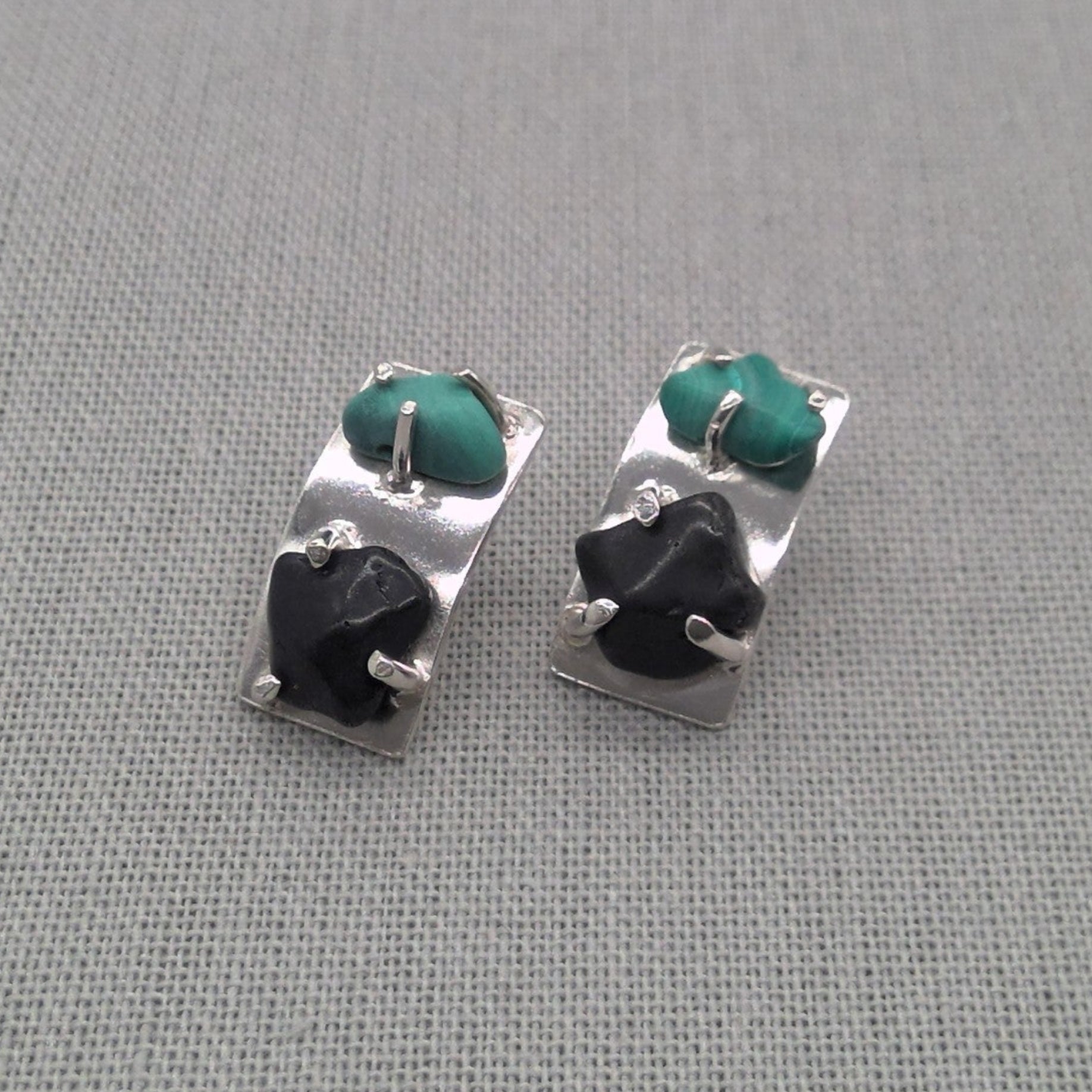Angled view of malachite and obsidian silver earrings