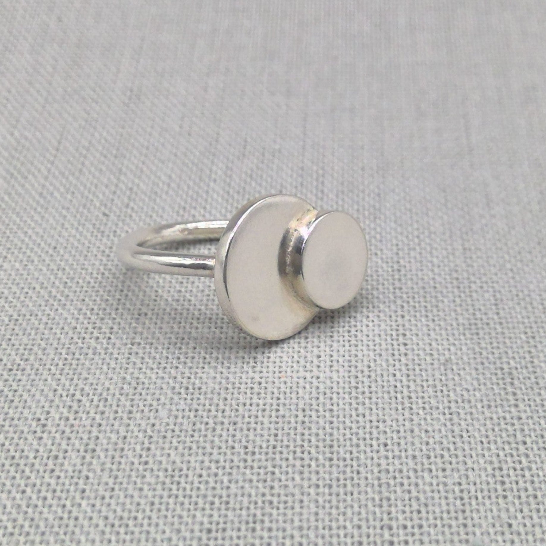 Personalised recycled silver ring with mother and daughter circles on fabric