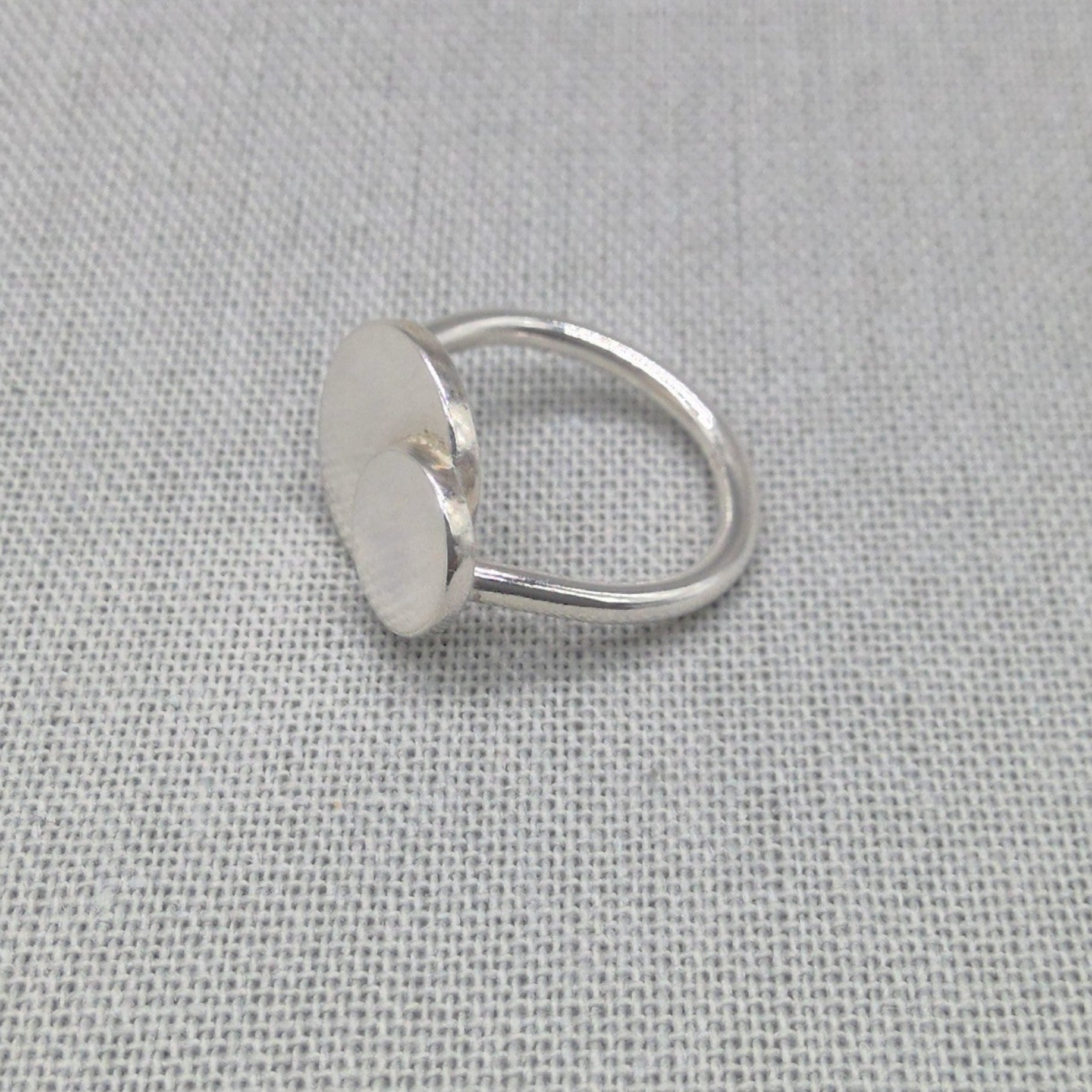 Angled view of personalised silver ring with large and small circle