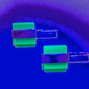 Two-tone neon Perspex earrings glowing under UV light
