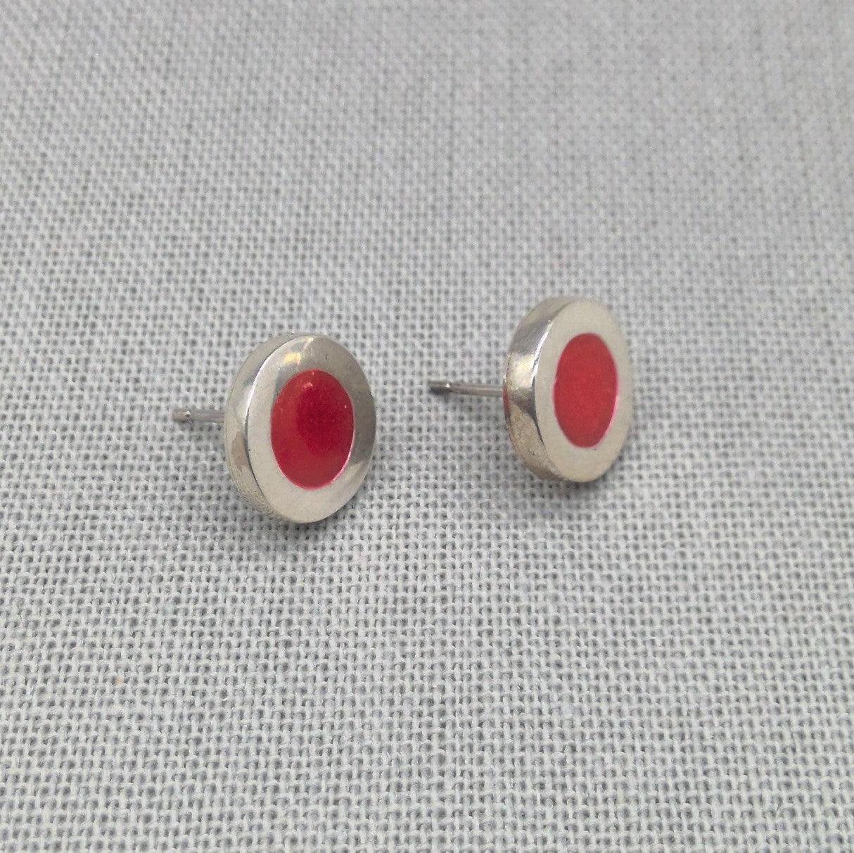Close-up of red neon resin recycled silver stud earrings