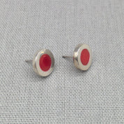 Close-up of red neon resin recycled silver stud earrings
