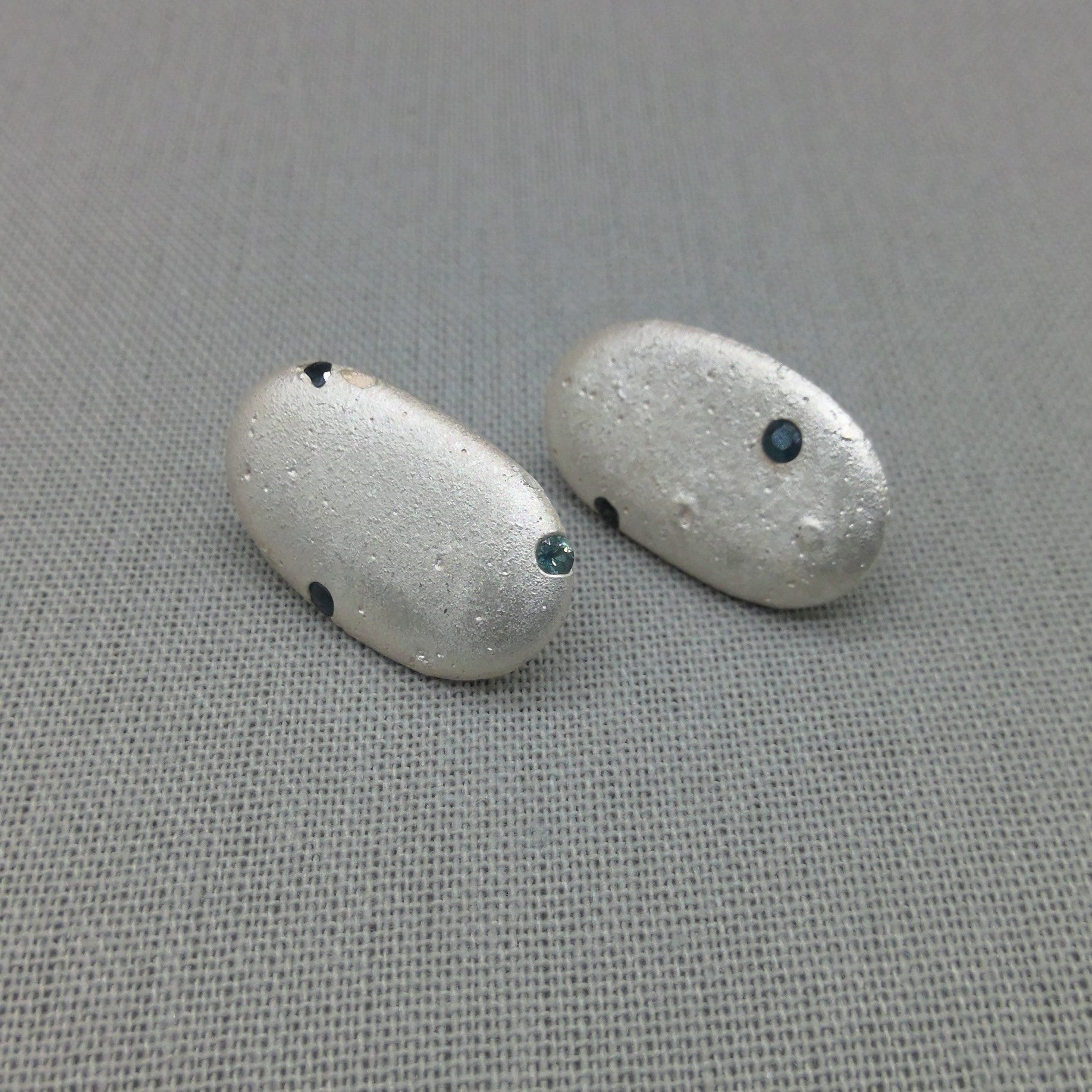 Close-up silver pebble earrings, natural organic texture