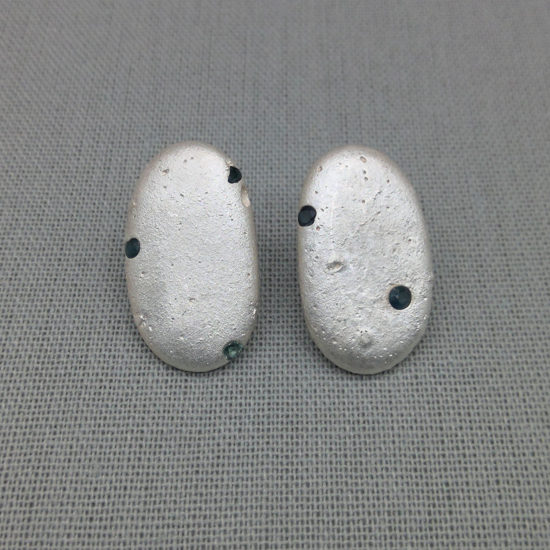 Silver pebble earrings cast from Cornish beach stones, set with blue sapphires