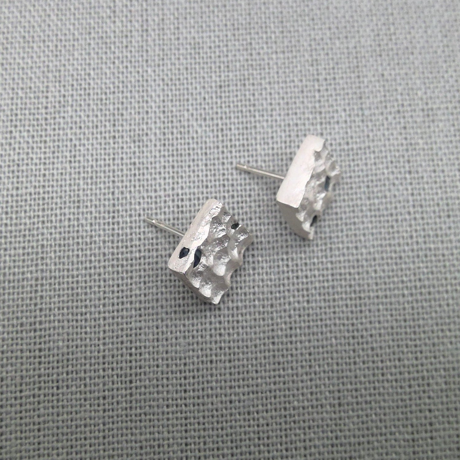 Textured silver stud earrings with natural blue sapphire gemstones