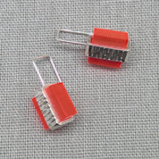 Detail of textured silver back on orange Perspex stud earring