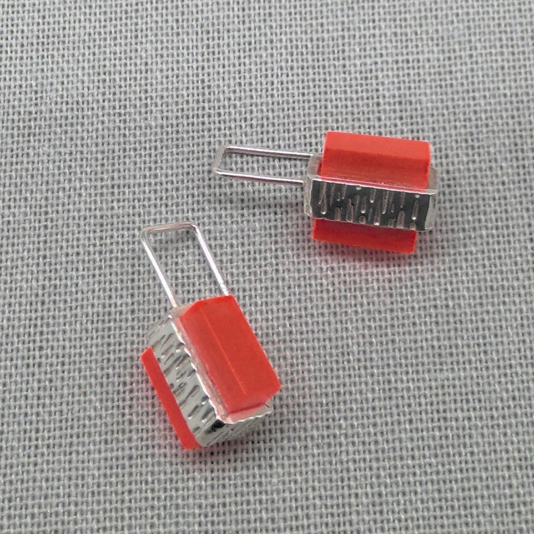 Top-down view of orange textured recycled silver earring