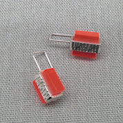 Top-down view of orange textured recycled silver earring