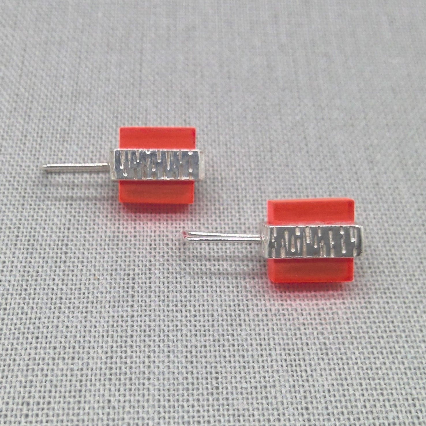 Angled view of orange textured recycled silver studs