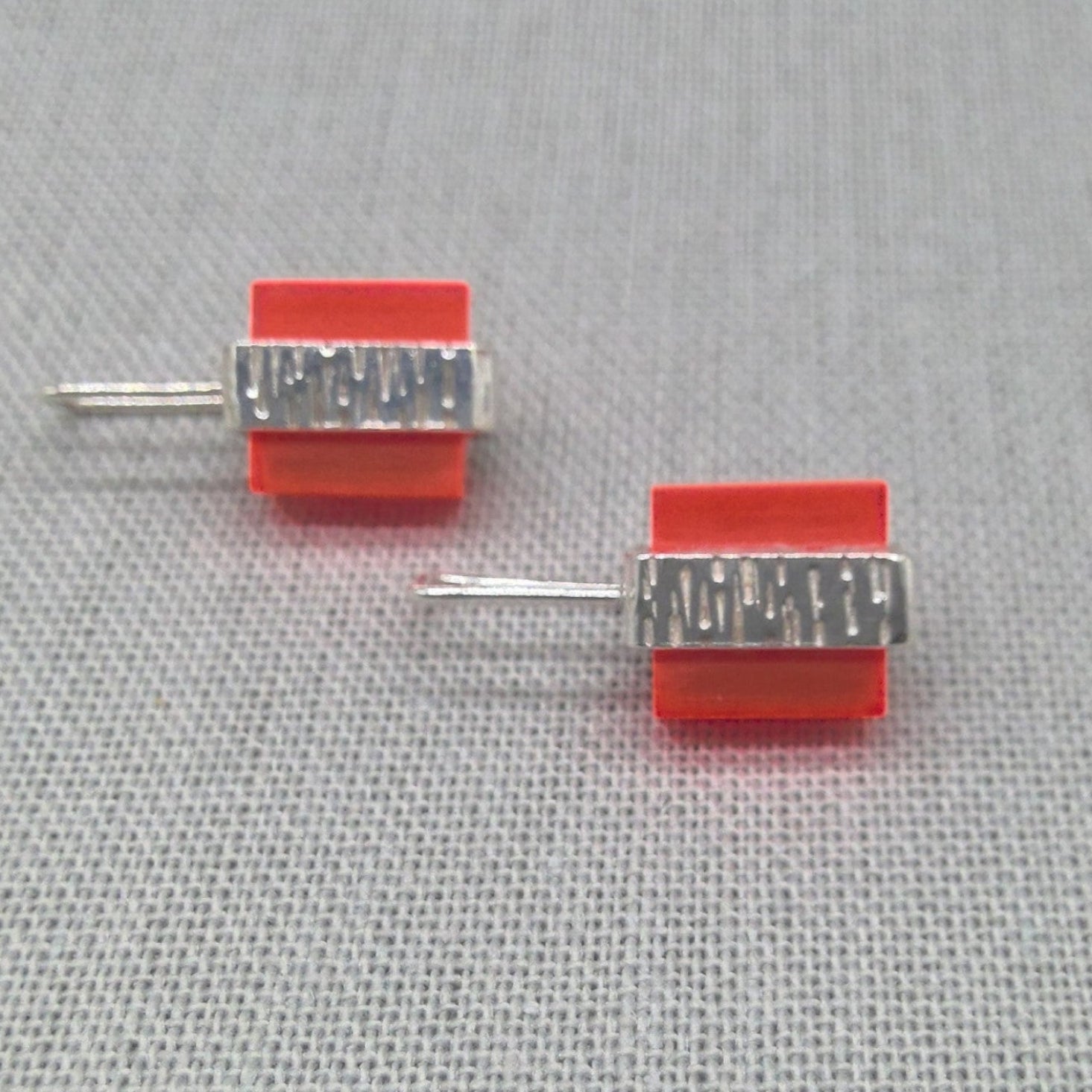 Side view of orange Perspex textured silver stud earrings