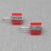 Side view of orange Perspex textured silver stud earrings
