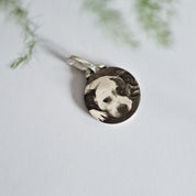 Personalised pet photo pendant hanging outdoors against greenery