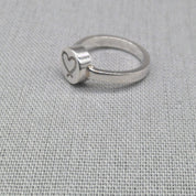 Personalised recycled silver ring with engraved heart disc on fabric