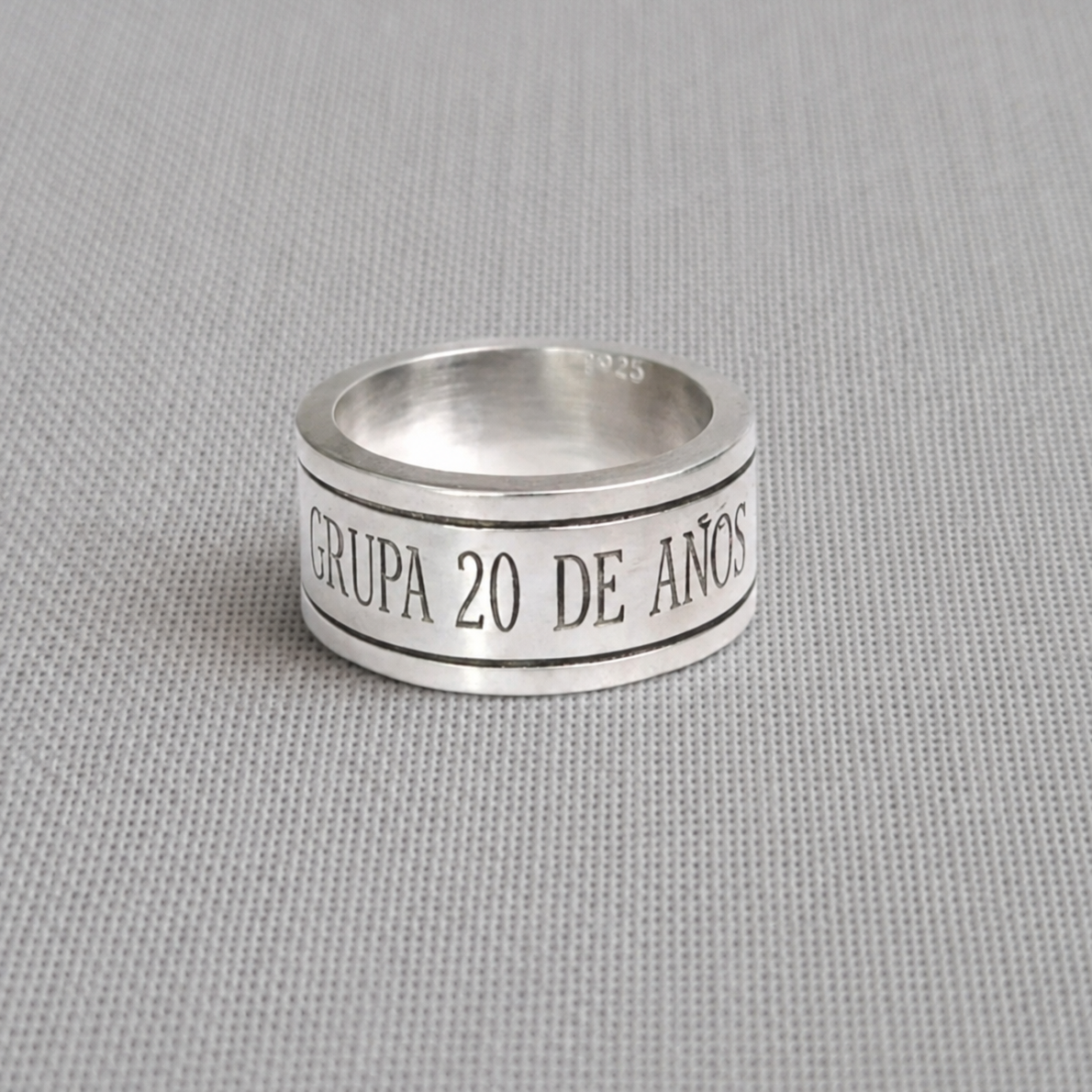 Engraved recycled silver spinning ring reading custom message on fabric