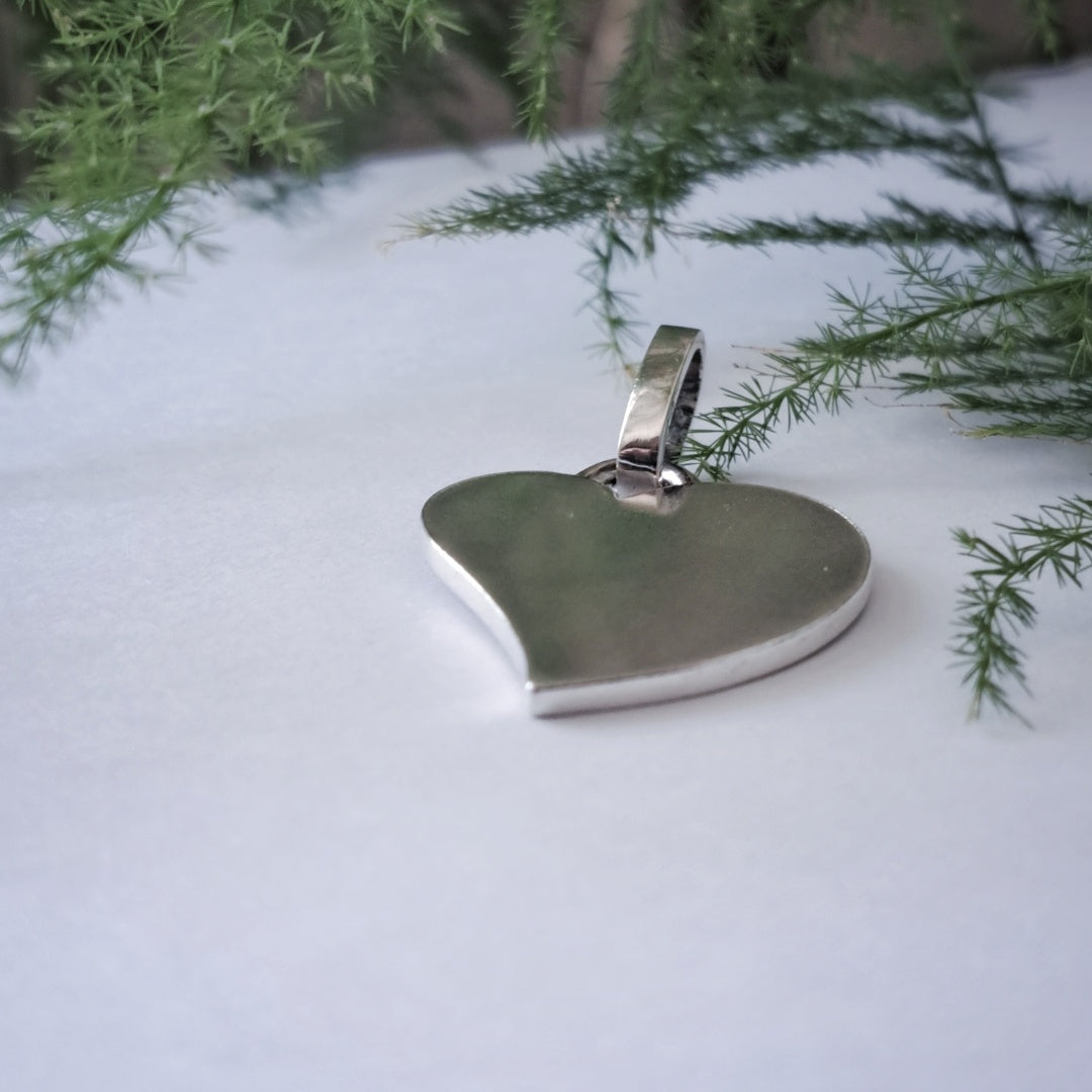 Close-up of recycled silver heart pendant in snowy outdoor setting
