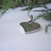 Close-up of recycled silver heart pendant in snowy outdoor setting