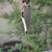 Silver heart pendant hanging detail shot showing bail and chain loop