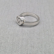 Angled view of personalised silver ring with heart engraving