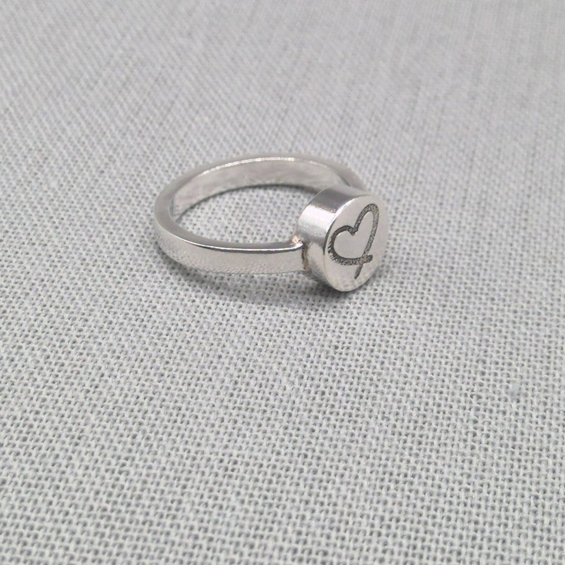 Side view of personalised silver ring showing raised disc detail