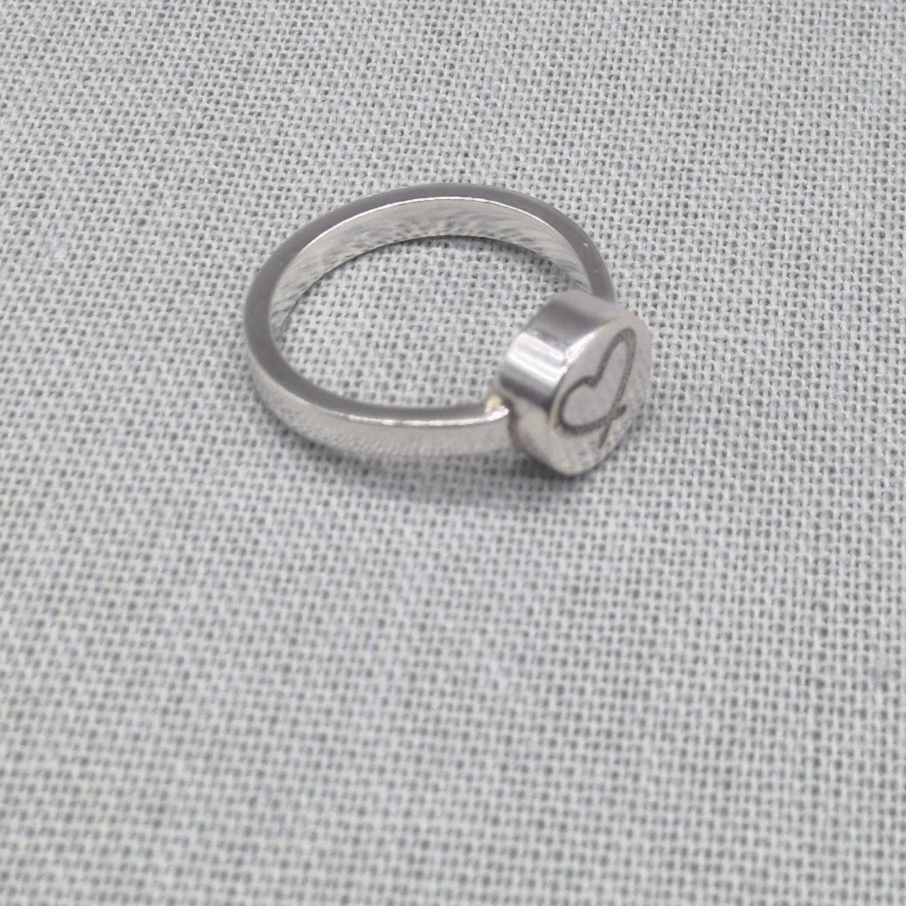 Alternate side view of engraved heart disc on recycled silver ring