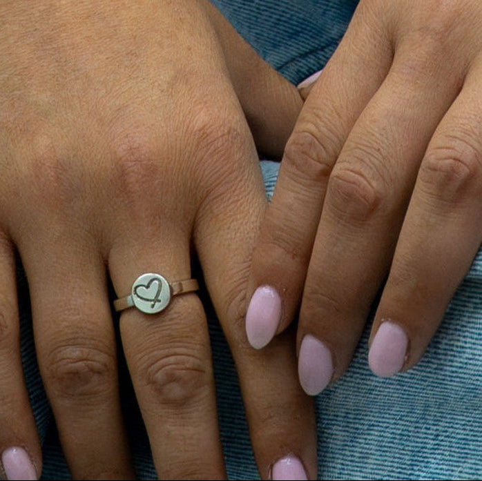 Personalised silver heart ring worn on finger