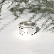 Recycled silver spinning ring with engraving photographed in natural light