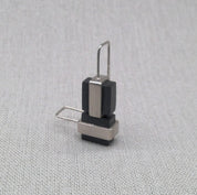 Angled view of black Perspex and silver drop earring
