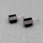 Flat lay of black Perspex and silver drop earrings