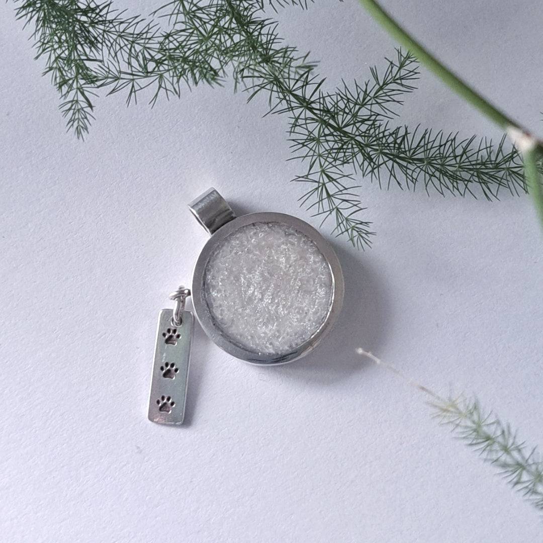 Close-up of paw print charm bar on recycled silver memorial pendant