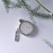 Close-up of paw print charm bar on recycled silver memorial pendant