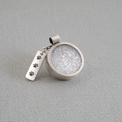 Recycled silver pet memorial ashes pendant with paw print charm on fabric