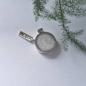 Side view of recycled silver memorial pendant showing resin ash centre