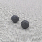 Oxidized black recycled silver ball stud earrings with hammered texture on fabric