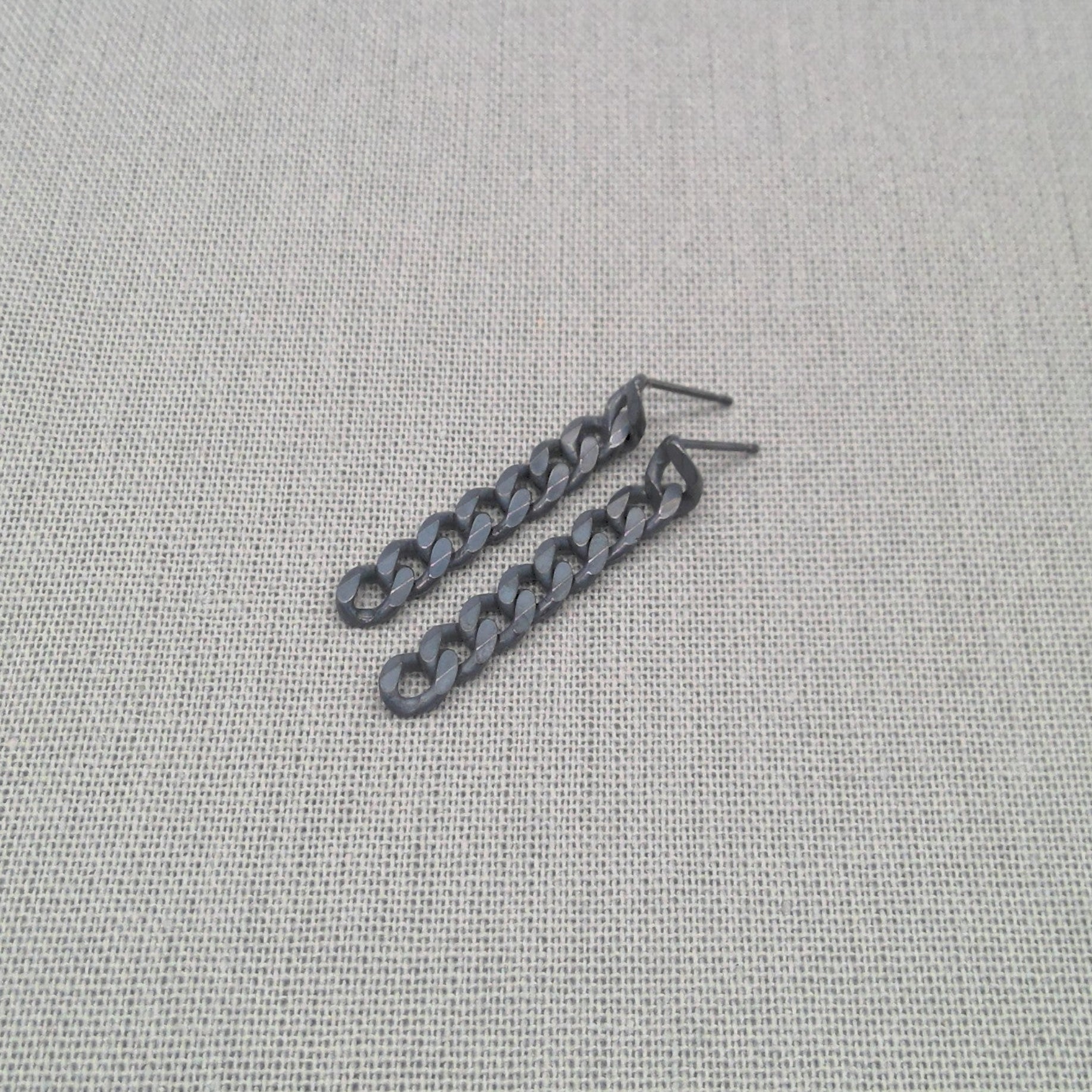 Detail shot of ear hook on black recycled silver chain earring