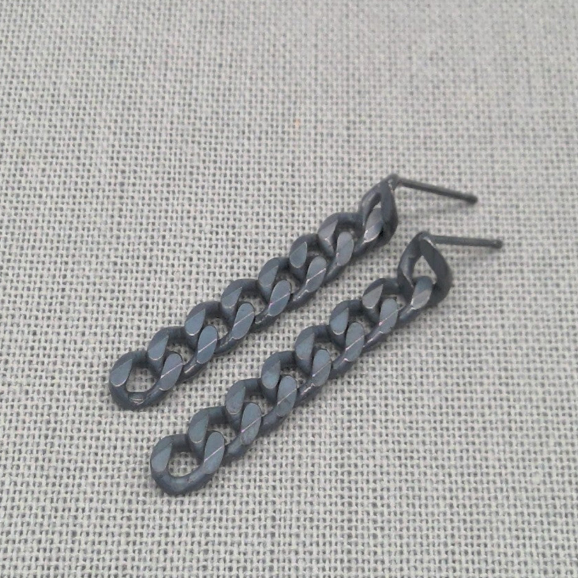 Close-up of oxidized black recycled silver chunky chain earrings
