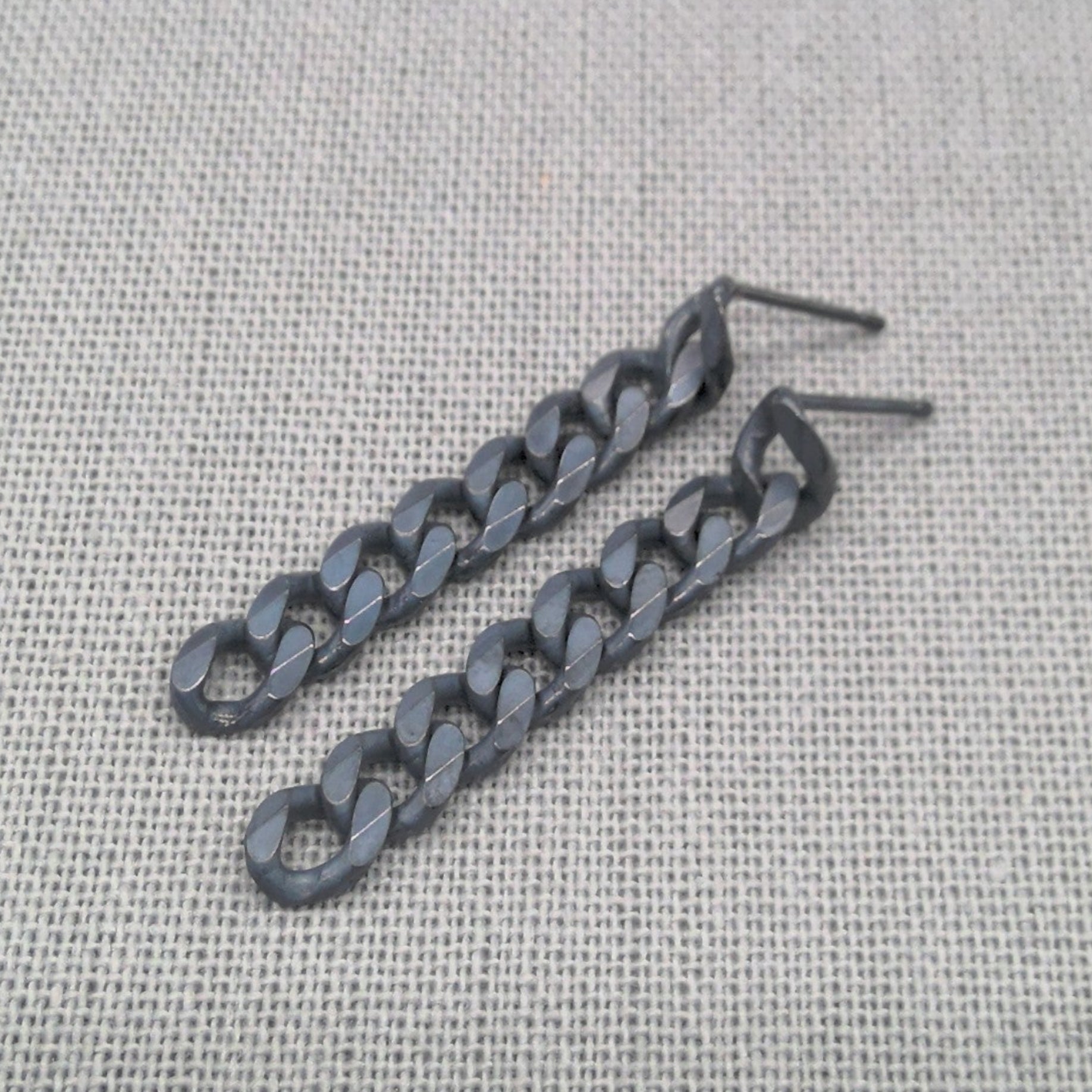 Recycled 925 silver chain earrings in black and silver finish laid on fabric