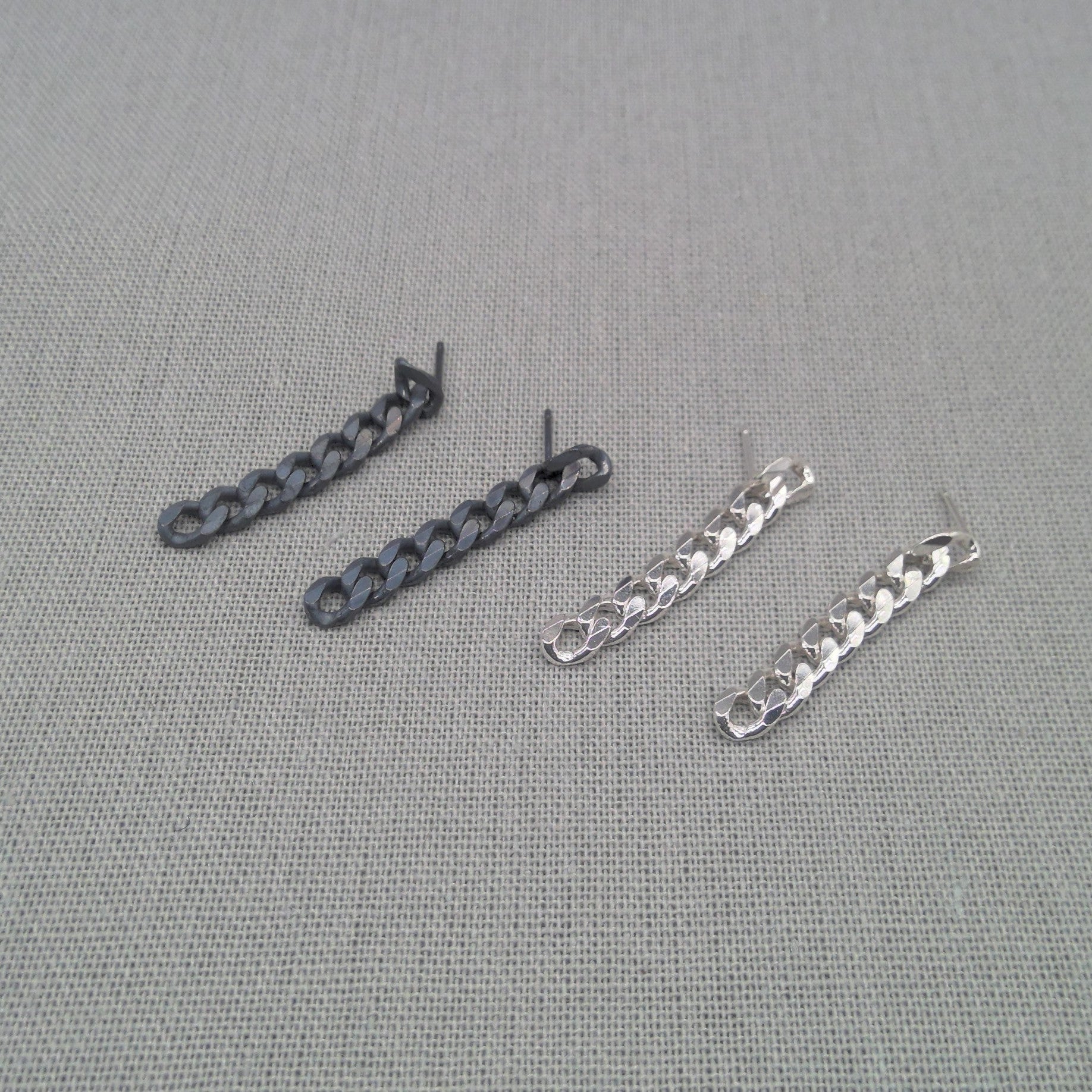 Black and silver-tone recycled silver chain earrings shown side by side