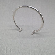 Recycled silver segmented open bangle with jointed links on fabric