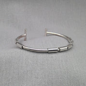 Side view of jointed segmented silver bangle with open design