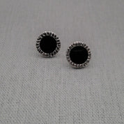 Black and white resin stud earrings in recycled silver on fabric