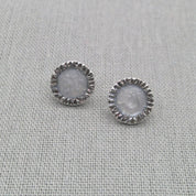 Pair of white resin stud earrings with textured silver edge
