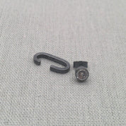 Close-up of black recycled silver cuff and zircon stud earrings