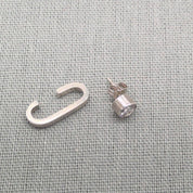Angled view of silver cuff stripe and zircon stud earrings