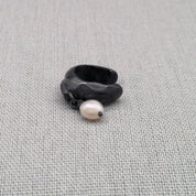 Angled view of black silver ear cuff with freshwater pearl