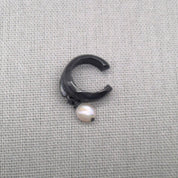 Front view of open oxidized silver ear cuff with pearl