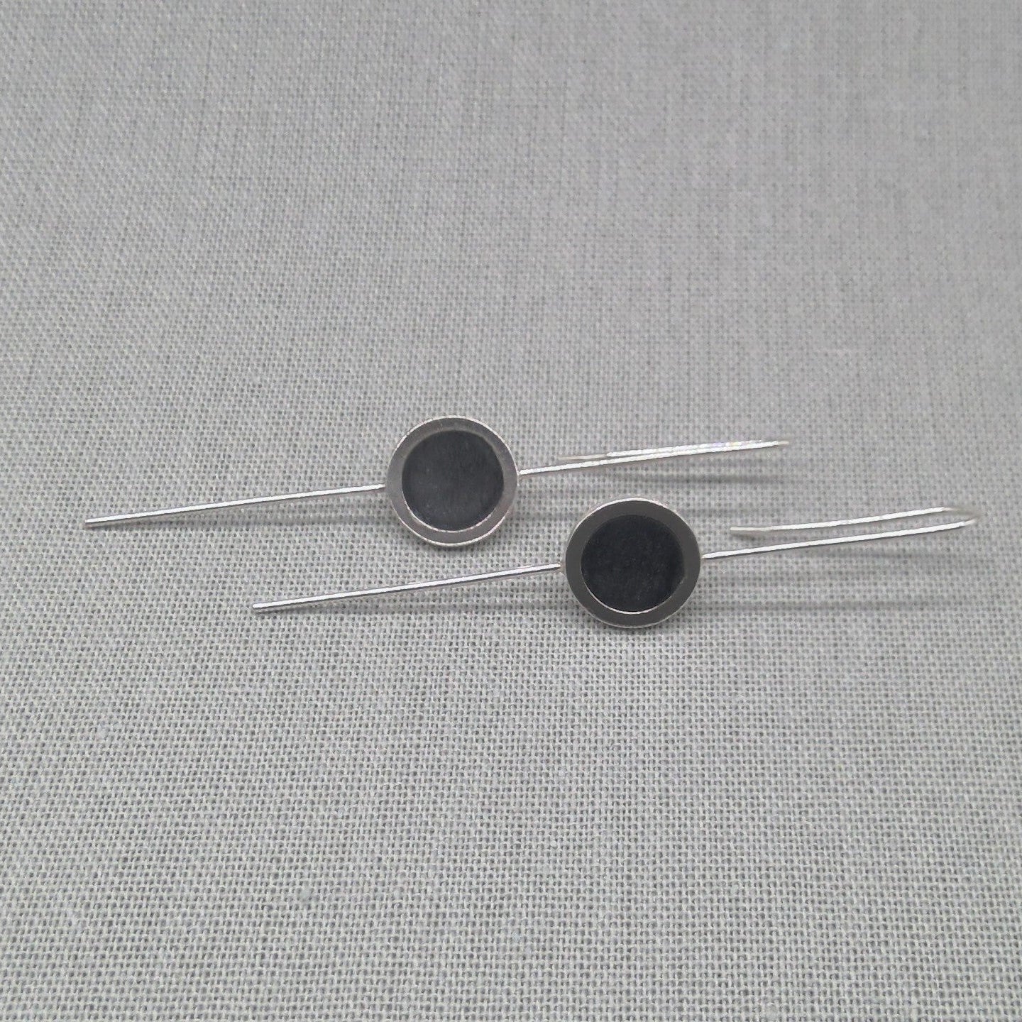 Horizontal flat lay of silver and resin drop earrings