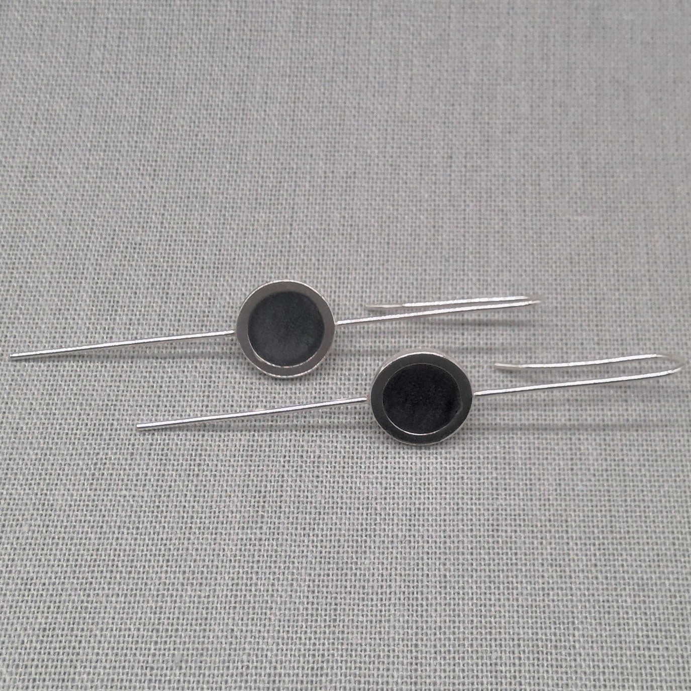 Horizontal flat lay of silver and resin drop earrings