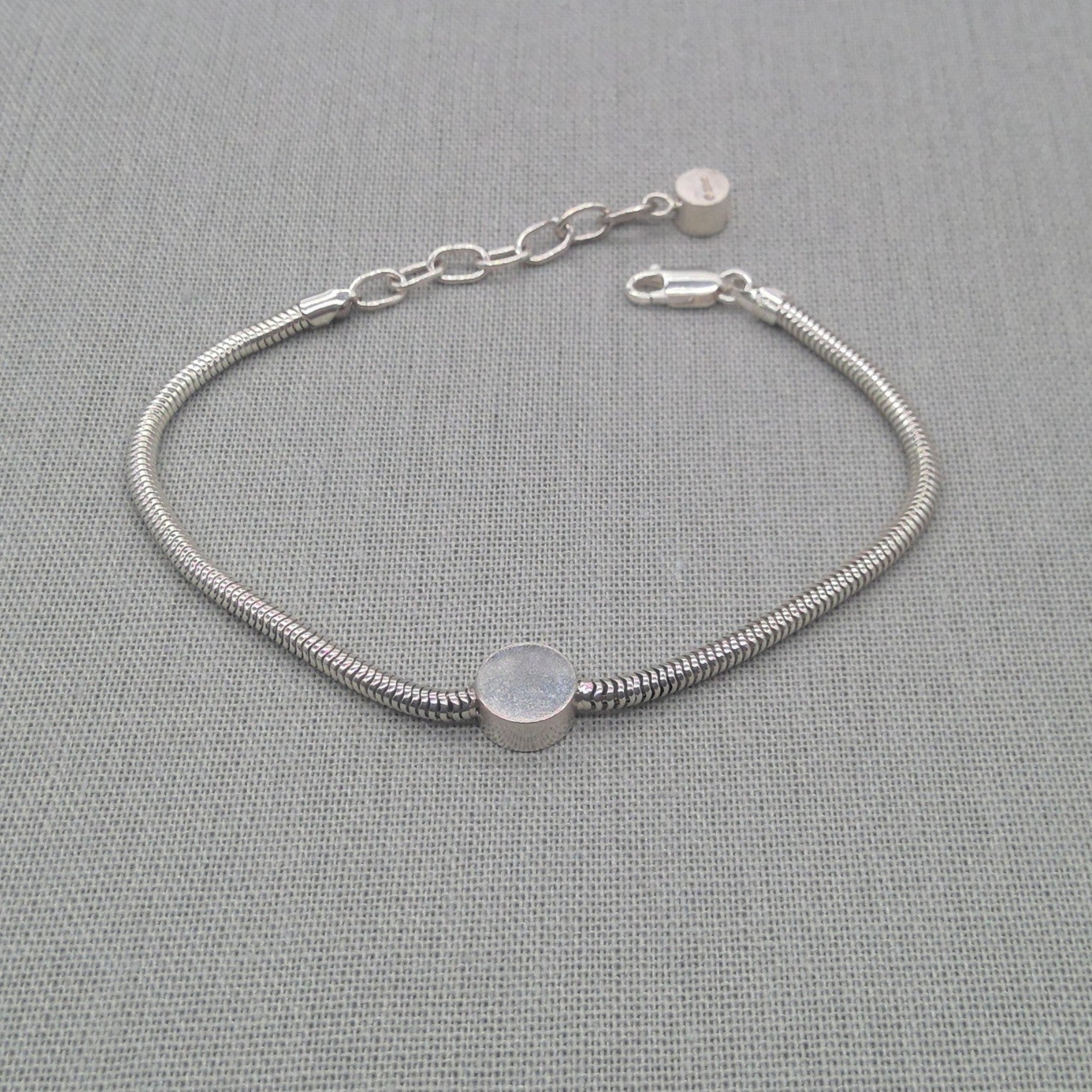 Front view of silver snake chain bracelet showing disc detail